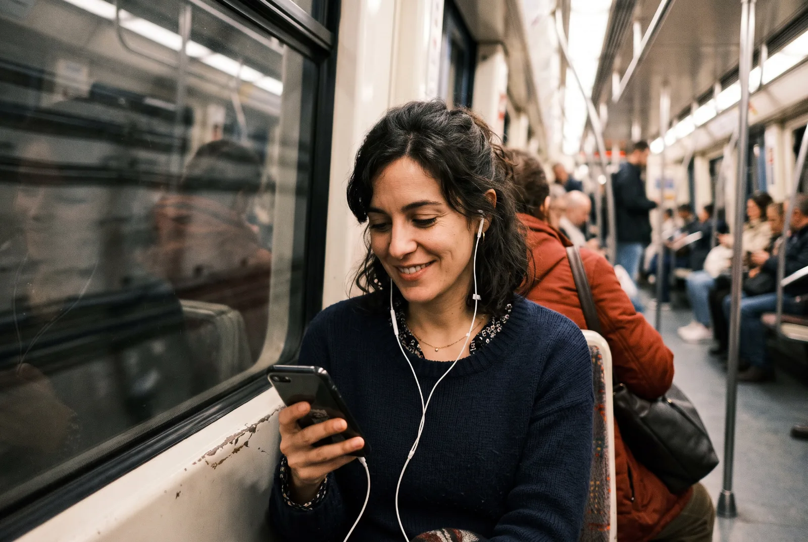 Una mujer repasa una hoja en el móvil en el metro